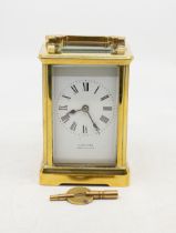 An early 20th Century gilt metal mounted 8 day carriage clock, white enamel dial with Roman