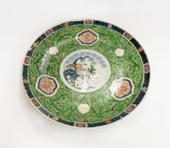 A Chinese large famille verte charger, the central section decorated with trees and balcony, with