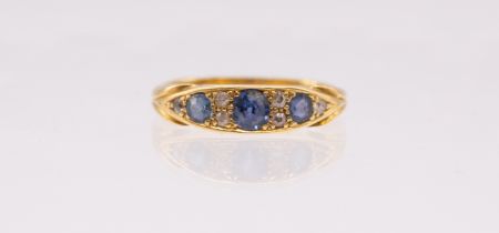 A sapphire and diamond 18ct gold boat head ring, comprising three round mixed cut sapphires and