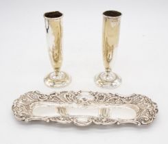 An early 20th Century silver pen tray, the raised sides chased with scrolls, flowers and open