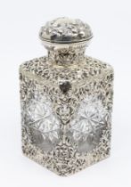 An Edwardian silver mounted cut glass large scent bottle, the bottle encased with a body chased