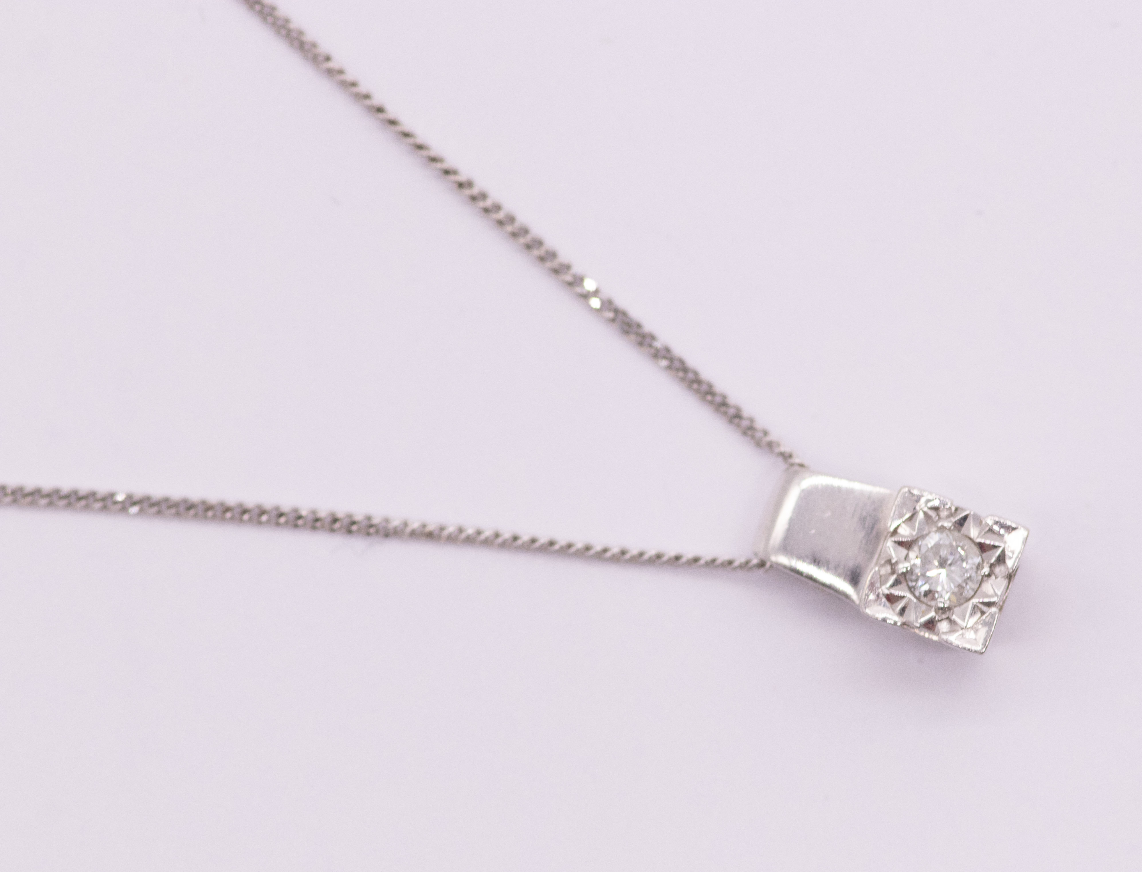 Single brilliant cut diamond in white cushion shaped illusion plate pendant, estimated dia wt 0.