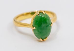 A jade and yellow metal dress ring, comprising an oval jadeite approx 10 x 7mm, claw set, to a