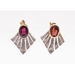 A pair of garnet and diamond stud earrings, each comprising a single oval garnet measuring approx