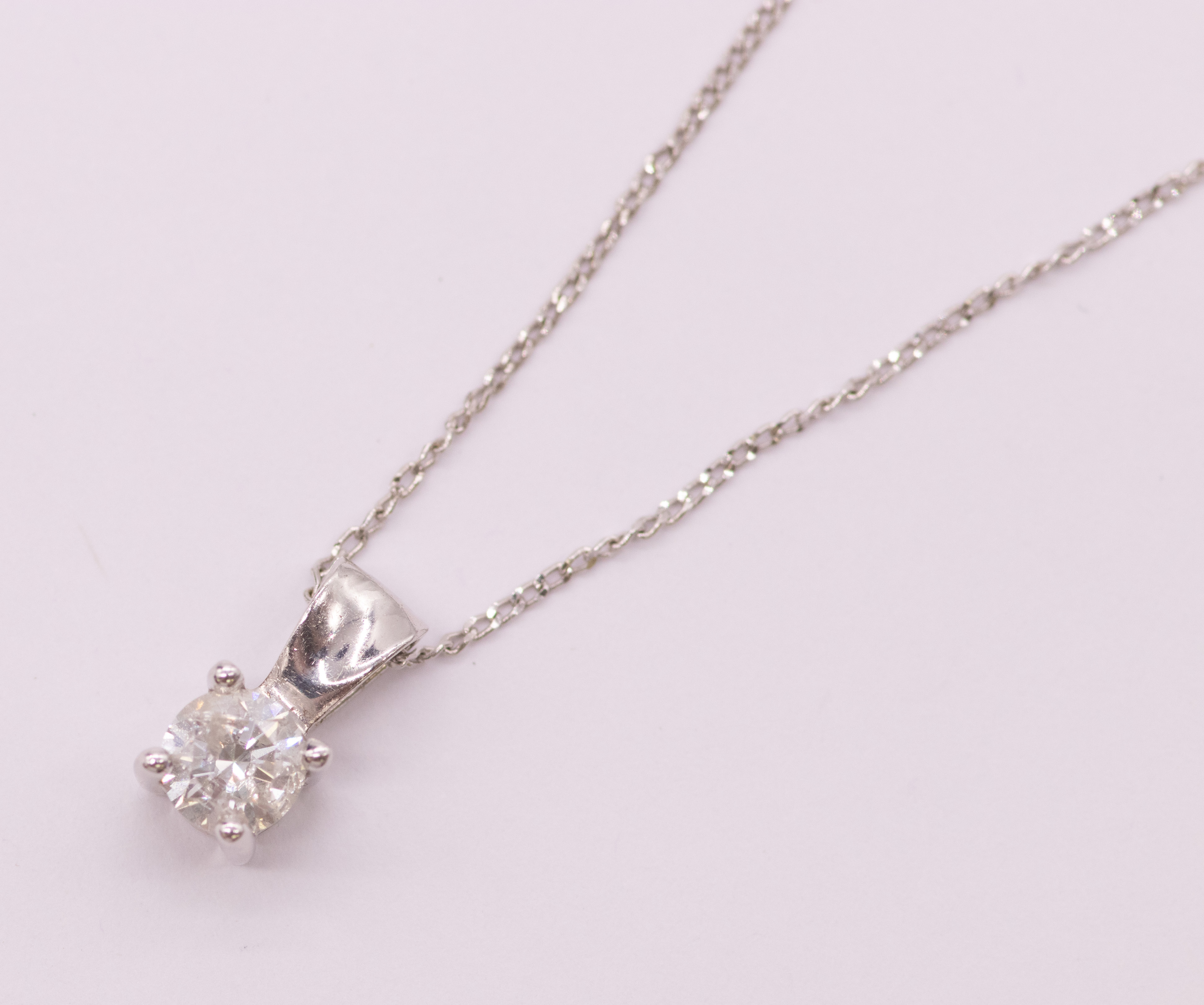 A diamond and 9ct white gold pendant and chain, comprising a round brilliant cut diamond weighing