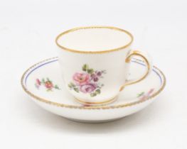 A Sevres tea cup and saucer, painted with floral sprays and gilt border and rims, puce Sevres mark