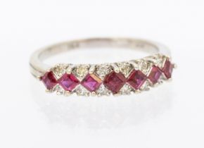 A ruby and diamond 18ct white gold half hoop design ring set with 12 brilliant cut diamonds with