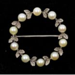 A pearl and white metal garland brooch, set with small cultured pearls and leaf decoration, diameter