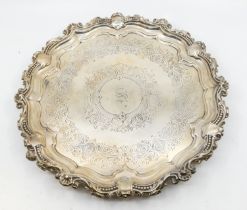 An Edwardian silver salver, having shell and ribbed fluted edge, engraved foliage design and central