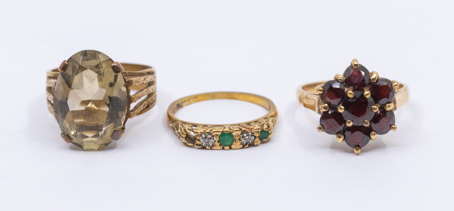 A collection of three gold stone set rings, comprising a garnet flower cluster, diameter approx