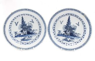 A pair of 18th century Delftware plates, painted in blue, diameter 23.2cm. (2) Condition note: