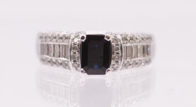 A centre rectangular cut blue sapphire ring measuring approx 6.7 x 4.9mm in raised four claw