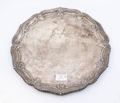 A late Victorian silver salver, having three bun feet, gadrooned and floral embossed rim, hallmarked