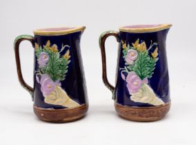 A pair of 19th Century Majolica water jugs, both with damage