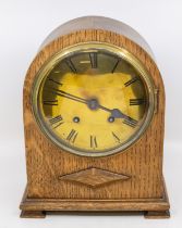 An early 20th Century oak cased 8 day mantle clock with brass face, Roman numerals in arched case.