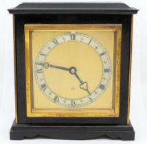 An ebonised Elliot mantel clock with Roman numerals and brass dial.