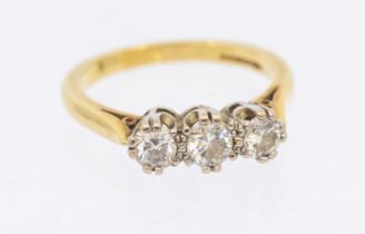 A diamond set 18ct gold three-stone ring, comprising claw set round brilliant cut diamonds, total
