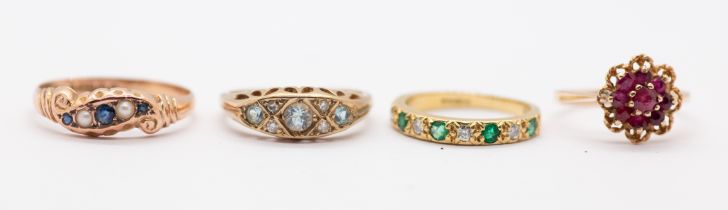 A collection of four stone set gold rings to include, an emerald and diamond 18ct gold half eternity