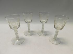 A set of four Georgian style large wine/drinking glasses, the bucket bowls engraved with flowers, on