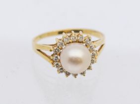 A pearl and diamond set 14ct gold cluster ring, comprising a cultured pearl to the centre within a
