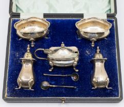 A matched George V/VI silver condiment set consisting of mustard pot with blue glass liner, two