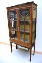 An Edwardian inlaid cabinet with glass panelled doors, shelving to interior.