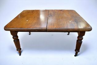 A Victorian wind out dining table, turned legs and castors.