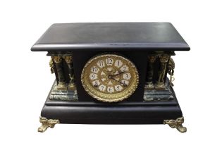 A late 19th/early 20th century slate style ebonised wooden cased mantle clock, having marble style