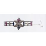 A sapphire, ruby and diamond set 18ct white gold brooch, comprising a open bar form with six sided