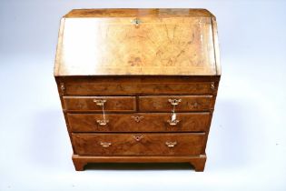 An early 19th century walnut veneer bureau, having drop down writing area (more modern felt), with