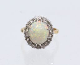 An opal cluster and diamond 18ct gold cluster ring, comprising an oval claw set opal approx 12 x