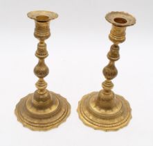 A pair of late 19th/early 20th century gilt bronze stylised candlesticks with knopped stems and