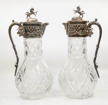 A pair of 20th century cut glass and silver plated claret jugs, having stylised relief masked spout,