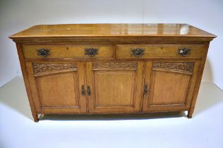 Art Nouveau solid sideboard with two single drawers above three cupboard doors.