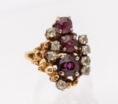 A Retro ruby and diamond gold set cluster ring, comprising a central round of claw set graduated