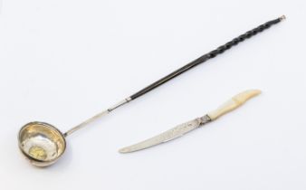 An 18th Century white metal toddy ladle, balen twist handle and gilt Queen Anne silver shilling to