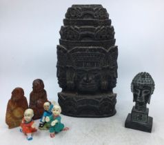 A collection of Asian figures to include an Asian carved wooden figure of a deity and others.