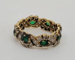 A precious yellow metal, emerald and diamond eternity ring, set eight pear-cut emeralds (one as