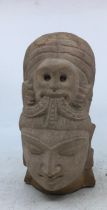 A Sino-Tibetan carved stone head of a deity.