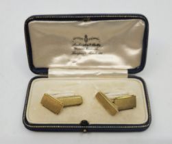 A pair of 18ct. gold rectangular engine turned cufflinks, chain fitting. (9.2g), in jewellers box.