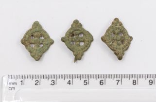 Three almost identical post-medieval copper alloy harness mounts, each with a pair of integral