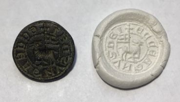 Medieval circular copper alloy seal matrix with a suspension loop located at the top. Seal design is