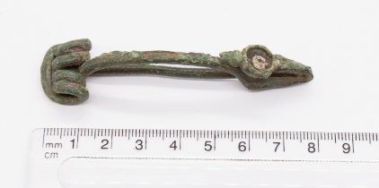 Iron age/Celtic La Tène fibula brooch made of a copper alloy. The catchplate head is turned back