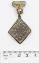 Medieval copper alloy lozenge Pendant and hanger depicting a blazing sun emblem. Traces of red