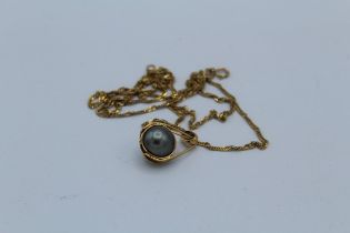 A Tahitian cultured pearl pendant, featuring a 10mm greenish grey single pearl in a yellow metal