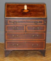 A George III mahogany and crossbanded bureau, with shell inlay to the fall front, over an