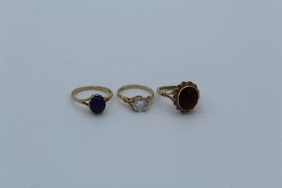 A group of three 9ct yellow gold dress rings, featuring a solitaire cubic zirconia ring, size K 1/2,