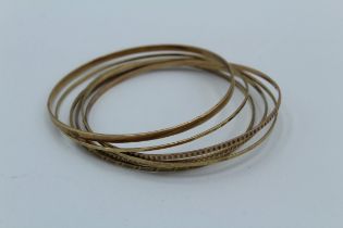 A collection of six '333' stamped precious metal bangles. Total weight 21.0gm. '333' is the German