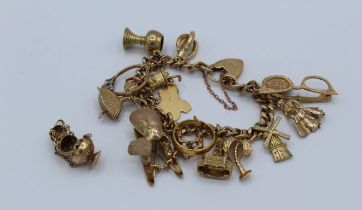 A charm bracelet, in 9ct gold featuring sixteen charms, including articulated spectacles, a 22ct