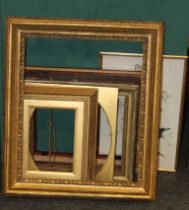 A quantity of 19th century and later giltwood frames, together with a dark wood example and a framed